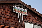 1330 Neon Address Sign of Aluminum, Copper, Panel of Corrugated Chicken Wire Glass and 4 neon tubes at dusk with the tubes lit, designed and hand-fabricated by Dwight H. Bennett